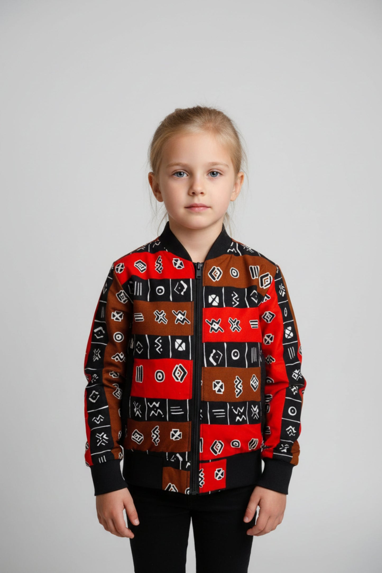 Bomber wax enfant rouge, noir et marron à motifs géométriques porté – Djêkoo Wax