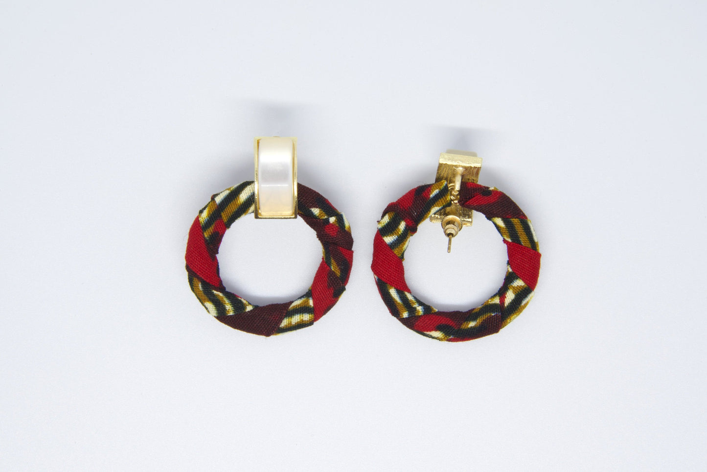 Vue dos paire de boucles d'oreilles créoles artisanales en tissu wax rouge bordeaux à motifs rayures diagonales doré kaki et noir montrant le système de fermeture tige dorée et clip rectangulaire - Bijoux africains Djêkoo Wax
