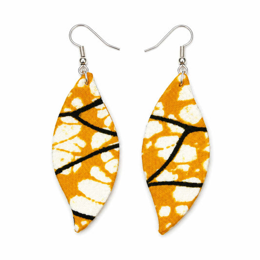 Paire de boucles d'oreilles artisanales en tissu wax africain, forme feuille, motif graphique orange, taches blanches et lignes noires — vue recto