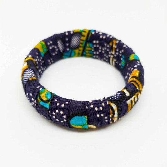 Bracelet jonc artisanal recouvert de tissu wax bleu foncé, rehaussé de touches turquoise, jaune et blanc.