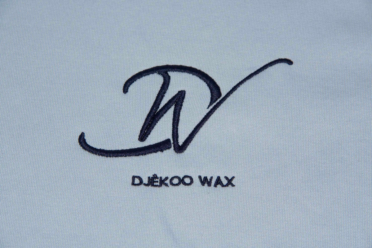 Détail de la broderie logo sur sweat à capuche bio femme bleu ciel Djêkoo Wax