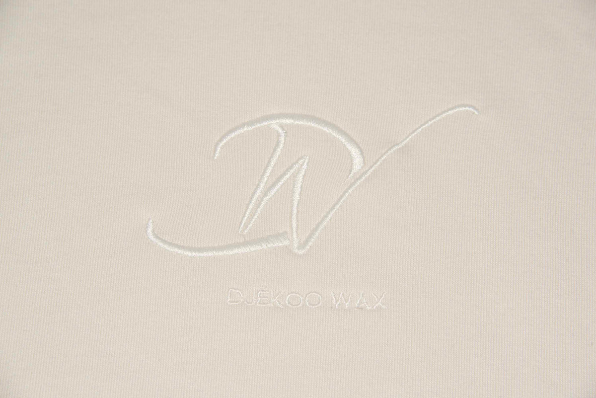 Détail du logo brodé sur sweat à capuche bio femme blanc cassé - Djêkoo Wax