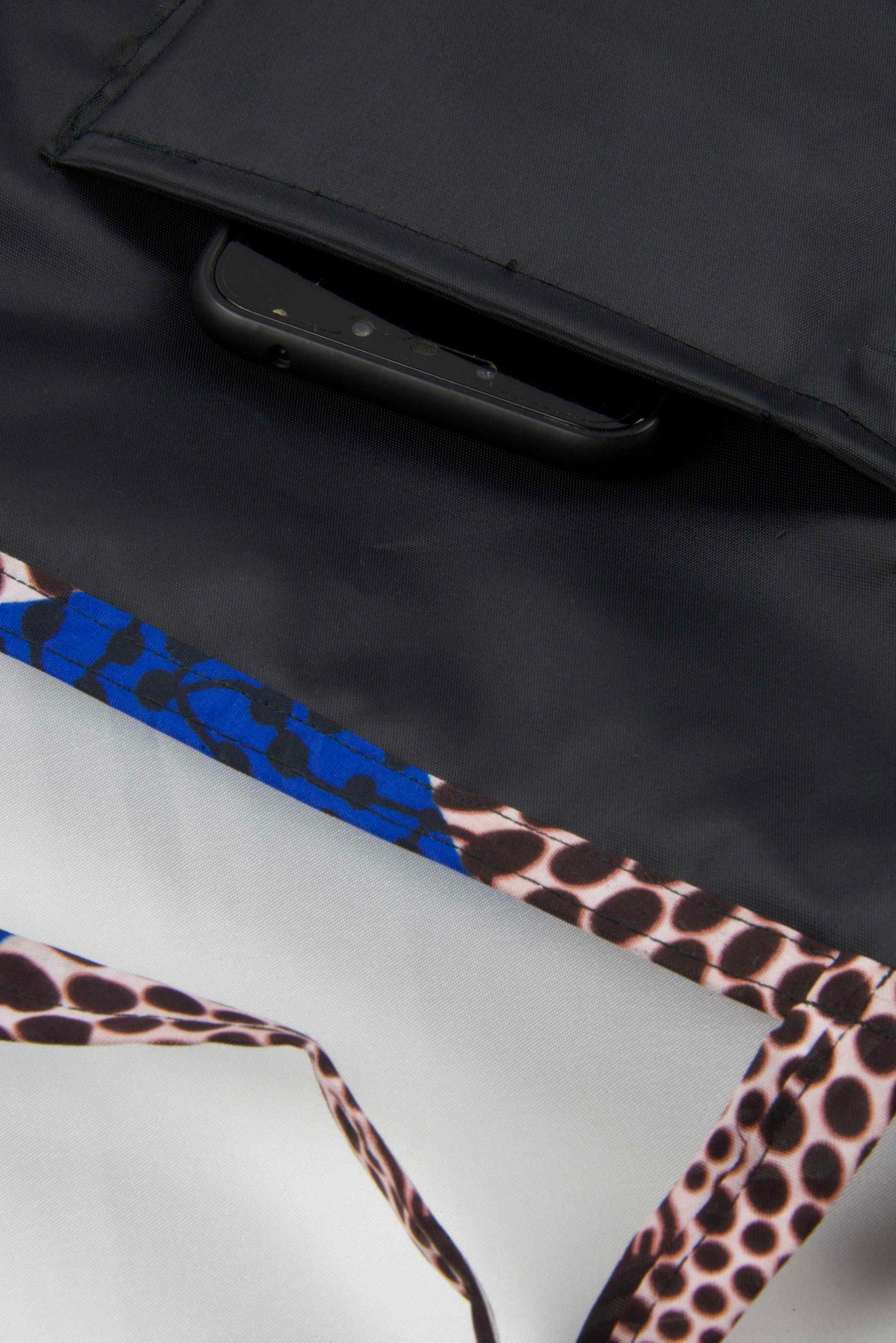 Détail de la doublure noire et de la poche intérieure du tote bag en wax bleu royal au motif Disque.