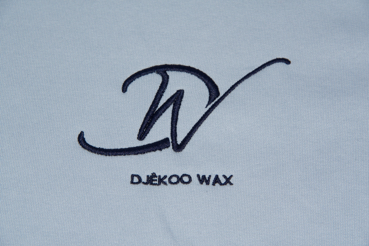 Une broderie du logo de la marque Djêkoo Wax de couleur Bleu Navy