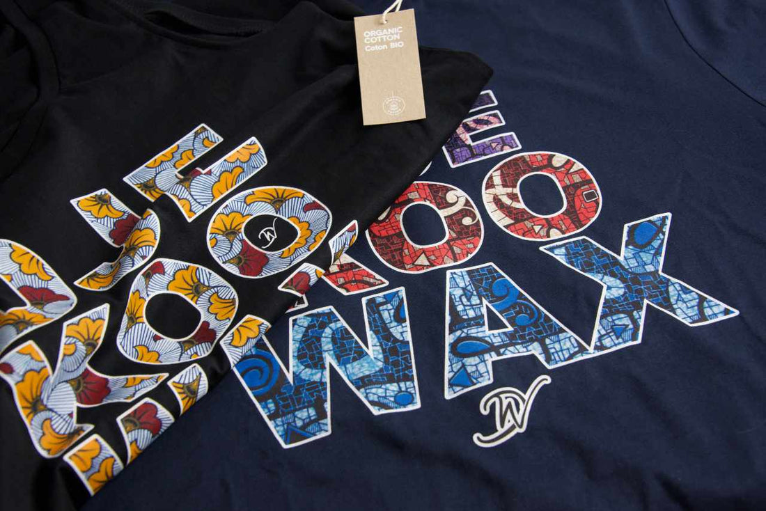 Gros plan sur deux t-shirts Djêkoo Wax noir et marine avec lettrage wax africain multicolore et étiquette Organic Cotton – t-shirt éco-responsable en coton biologique