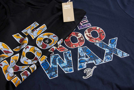 Gros plan sur deux t-shirts Djêkoo Wax noir et marine avec lettrage wax africain multicolore et étiquette Organic Cotton – t-shirt éco-responsable en coton biologique