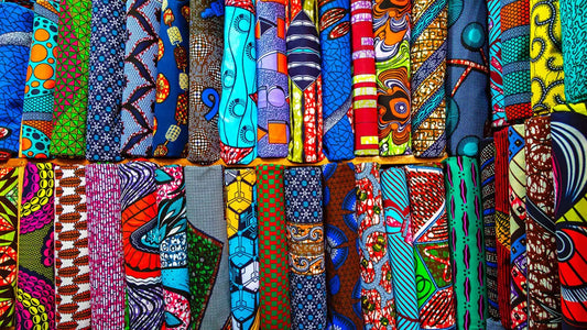 Tissus wax africains multicolores pliés et rangés côte à côte – large sélection de motifs wax premium Djêkoo Wax
