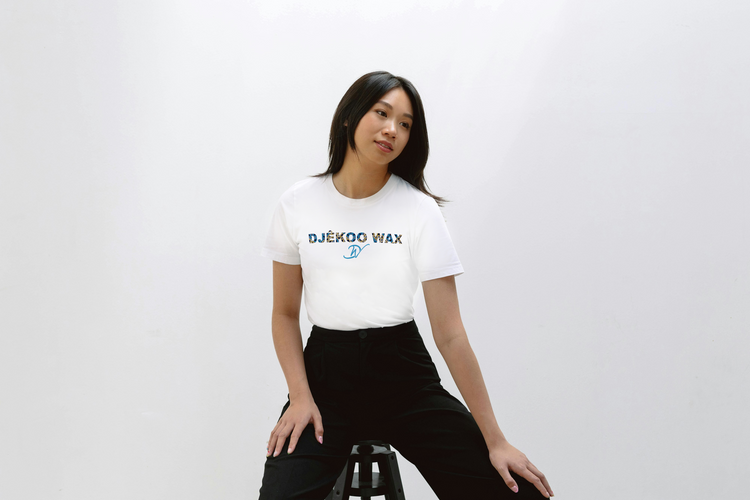 Femme portant un t-shirt blanc avec motidfs wax coupe unisexe 