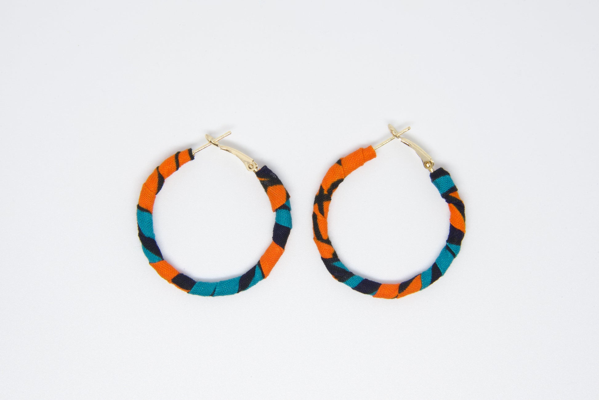 Boucles d'oreilles style créole fait main en tissu wax de couleurs orange, noir et bleu turquoise 