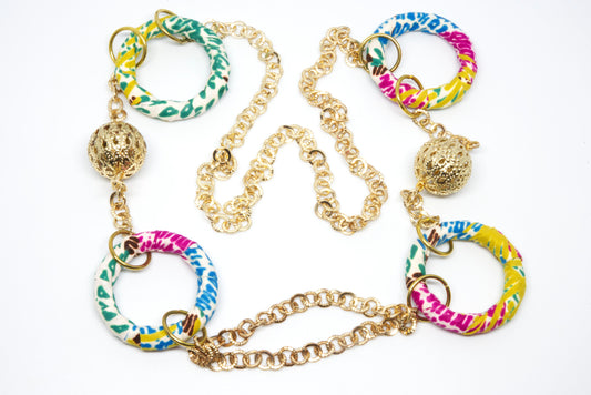 Sautoir artisanal en tissu wax multicolore avec anneaux recouverts et perles dorées ajourées - Djêkoo Wax