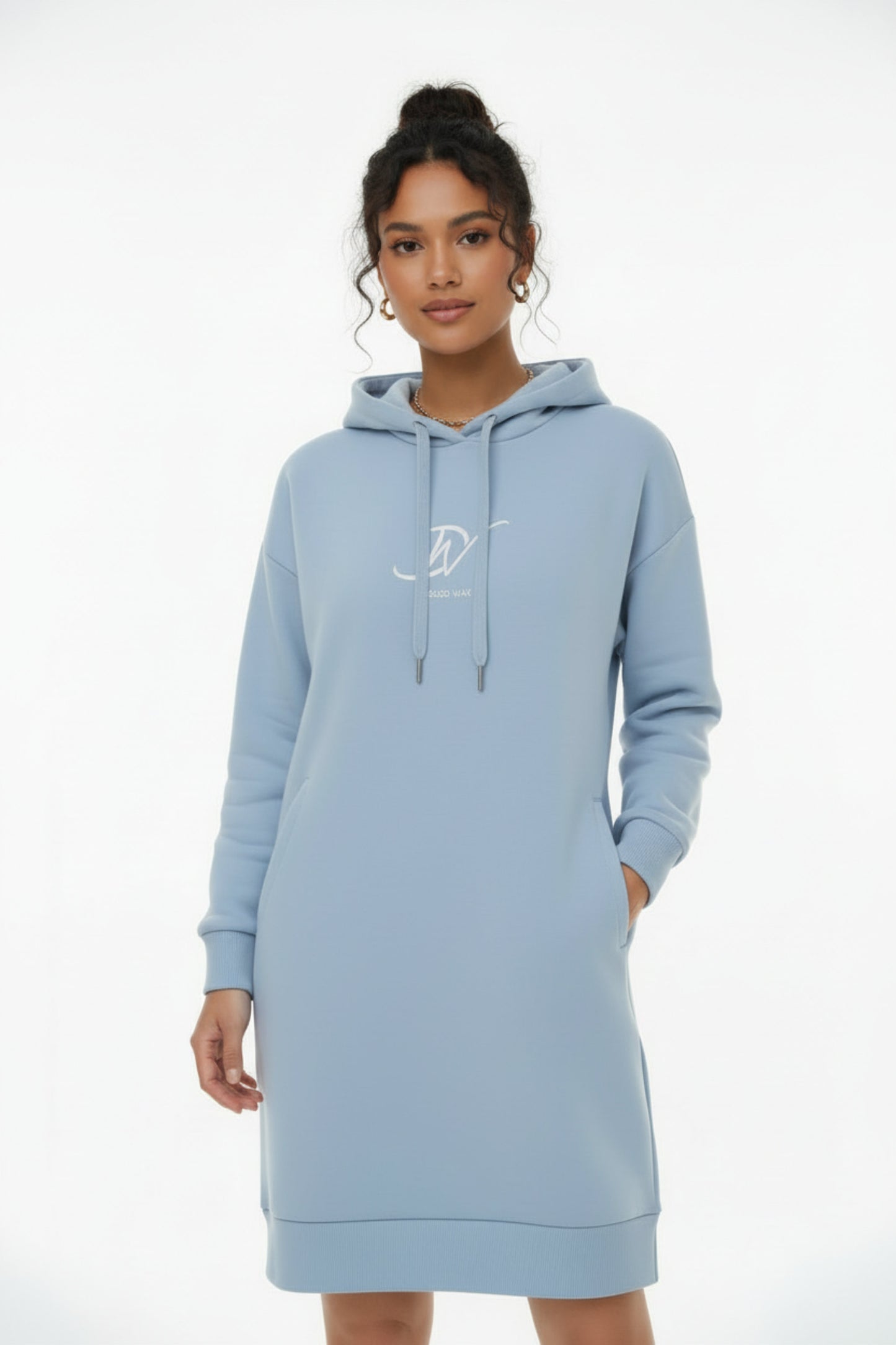 Femme portant une robe sweat bleu ciel avec capuche kangourou et logo Djêkoo Wax blanc - Mode casual chic