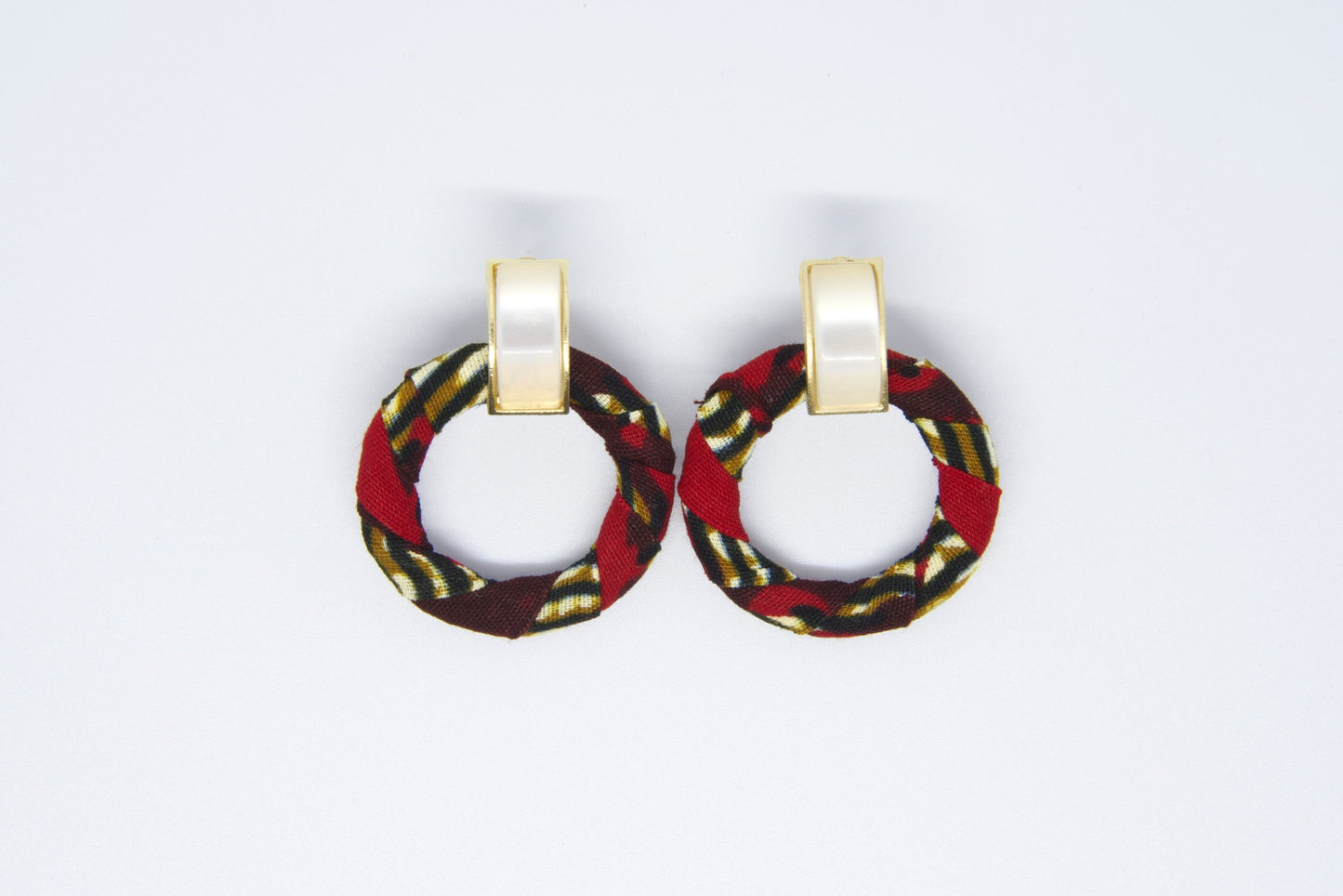 Paire de boucles d'oreilles créoles artisanales en tissu wax rouge bordeaux à motifs rayures diagonales doré kaki et noir avec anneau rond et clip rectangulaire doré nacré - Bijoux africains premium Djêkoo Wax

