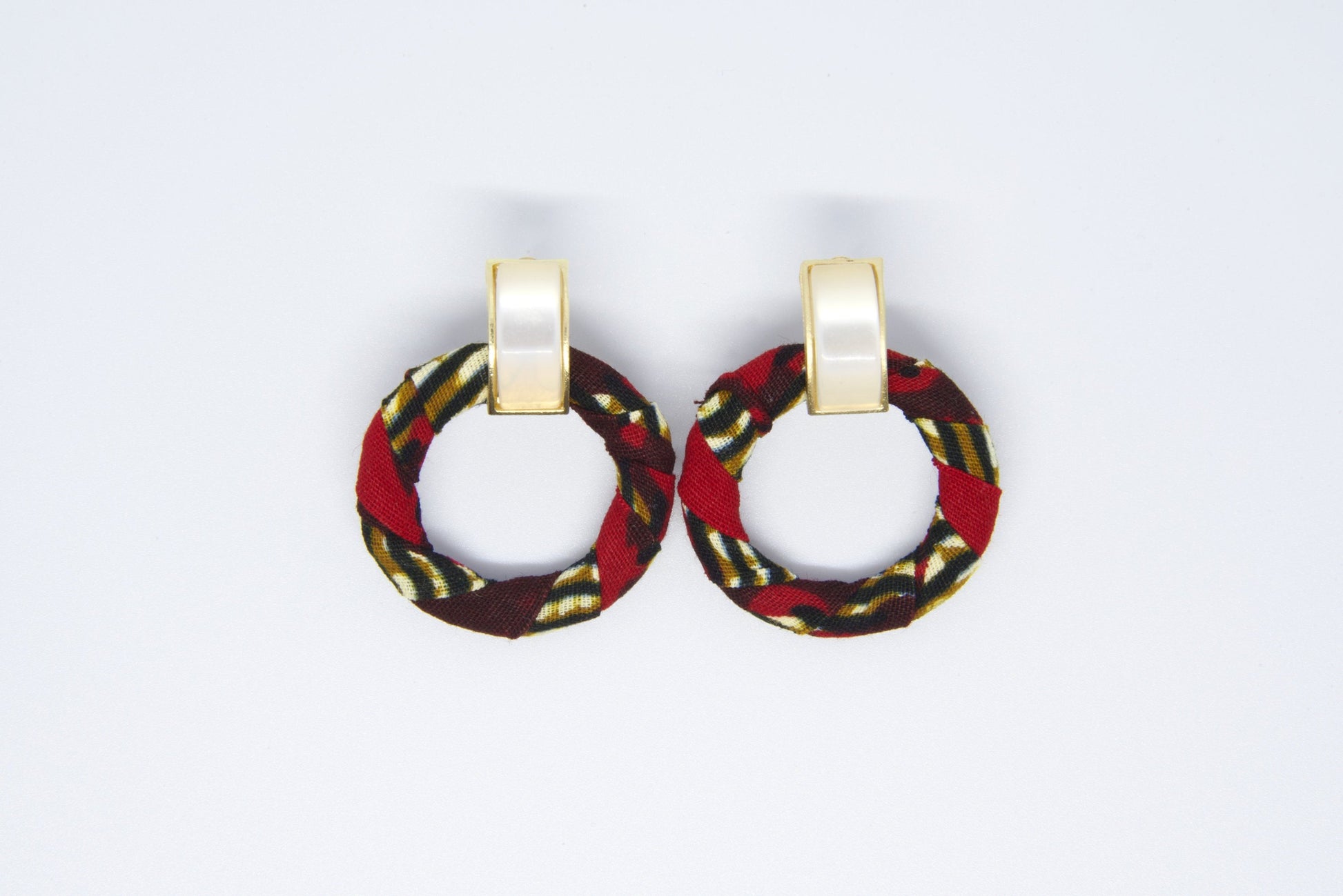Paire de boucles d'oreilles créoles artisanales en tissu wax rouge bordeaux à motifs rayures diagonales doré kaki et noir avec anneau rond et clip rectangulaire doré nacré - Bijoux africains premium Djêkoo Wax

