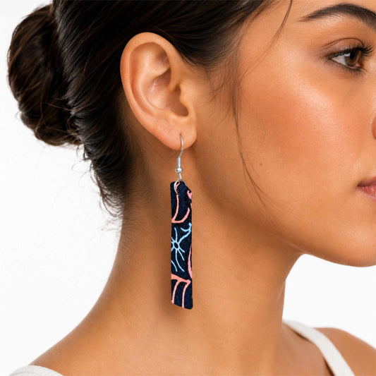 Boucles d'oreilles longues artisanales en tissu wax africain, motif abstrait marine, rose et bleu — portées en situation