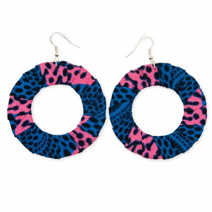 Paire de boucles d'oreilles artisanales en tissu wax africain, forme cercle ajouré, motif animalier léopard bicolore bleu électrique et rose fuchsia — vue produit