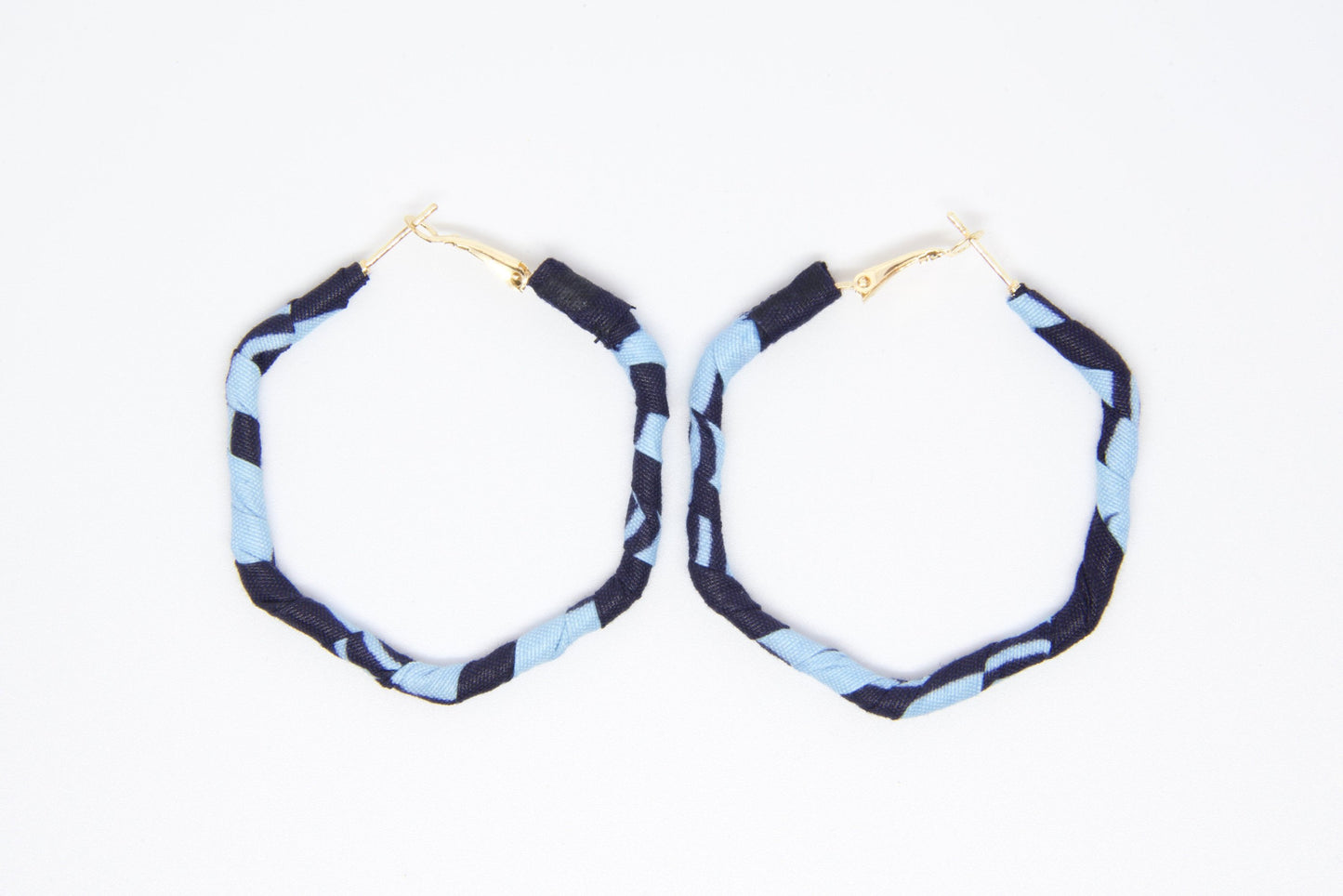 Boucles d’oreilles artisanales rondes en tissu wax bleu ciel et bleu marine de la Parure Nina.
