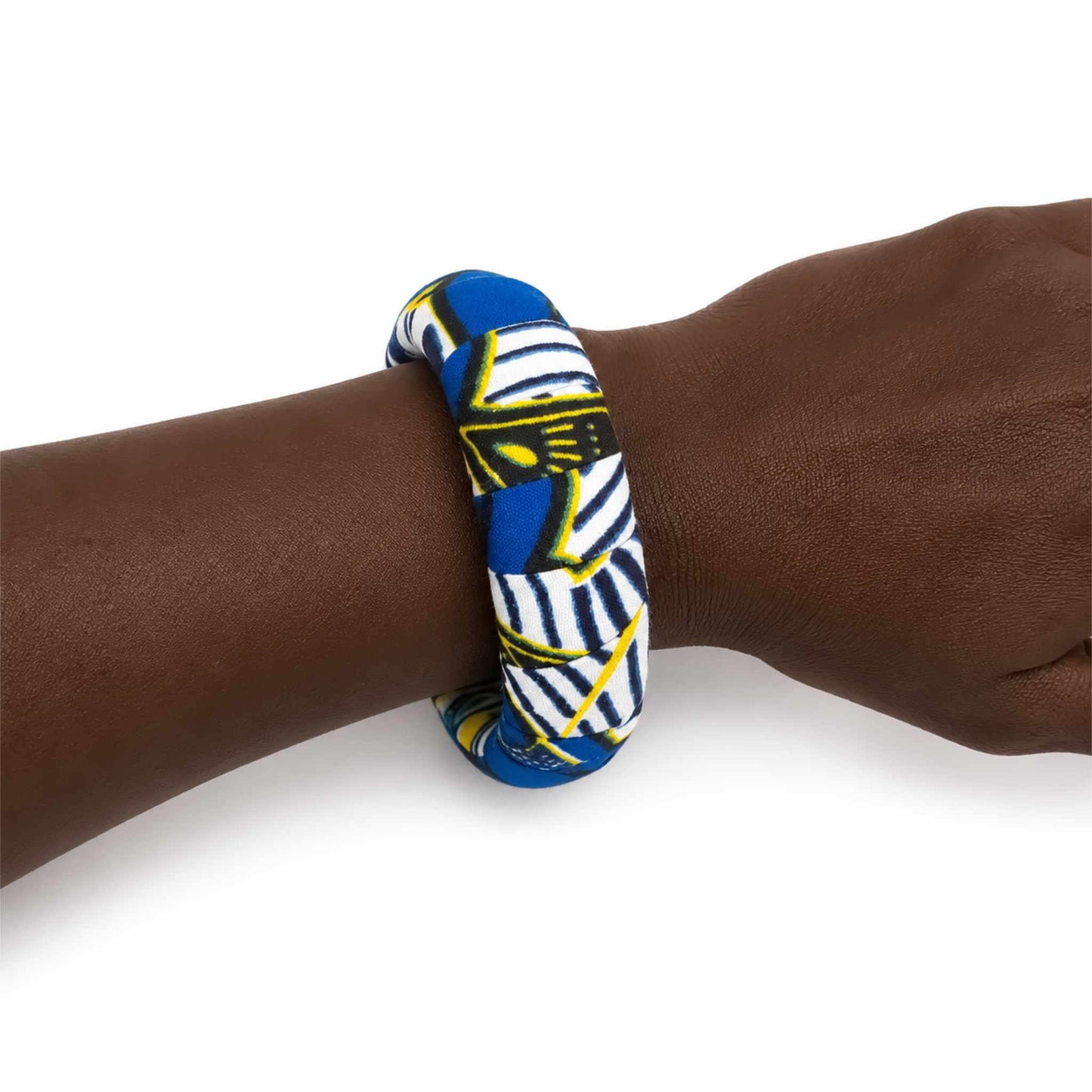 Bracelet africain artisanal large recouvert de tissu wax bleu, blanc, noir et jaune, présenté porté au poignet sur fond blanc.