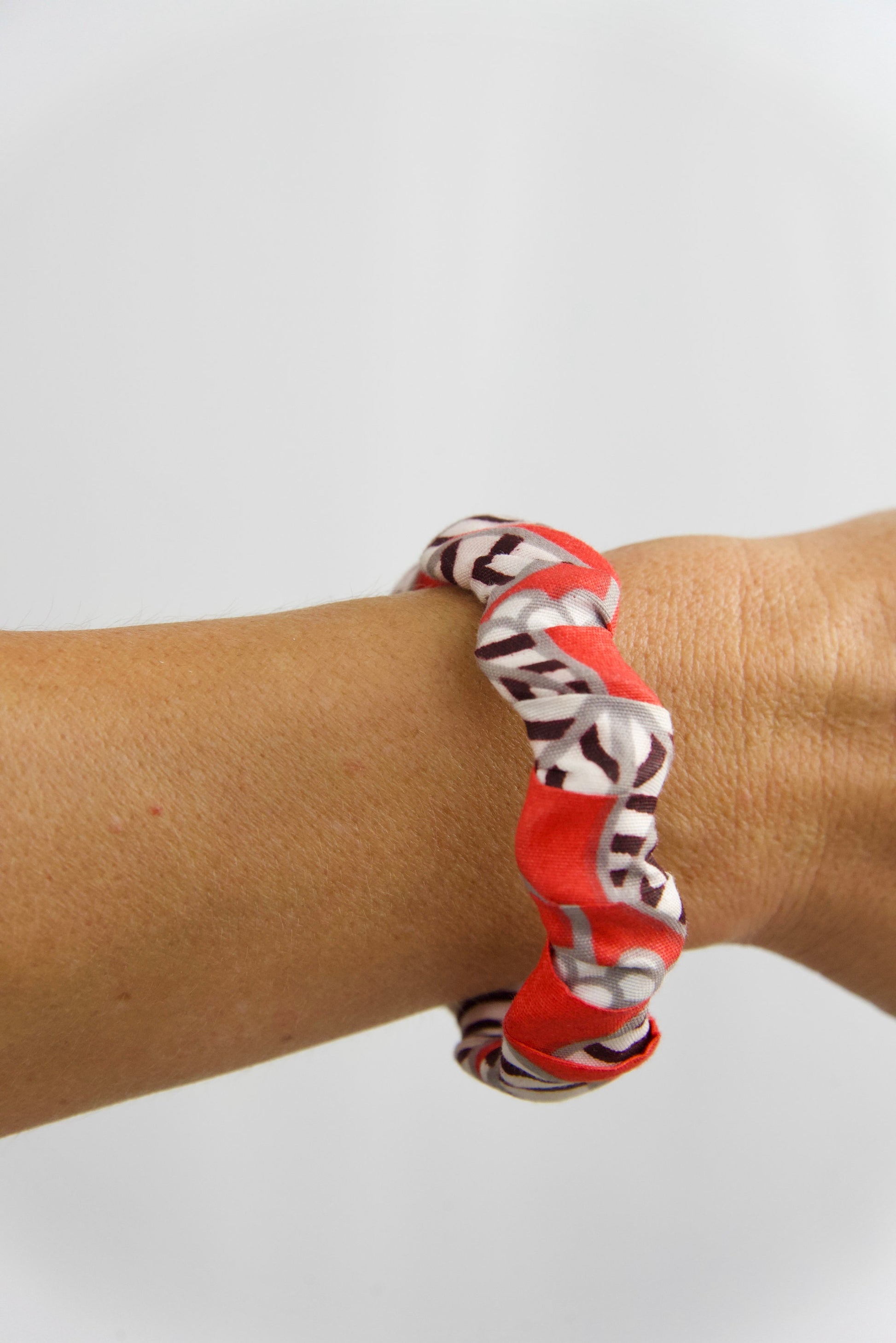 bracelet artisanal femme en bois et tissu wax fait main, de couleurs rouge, blanc, gris