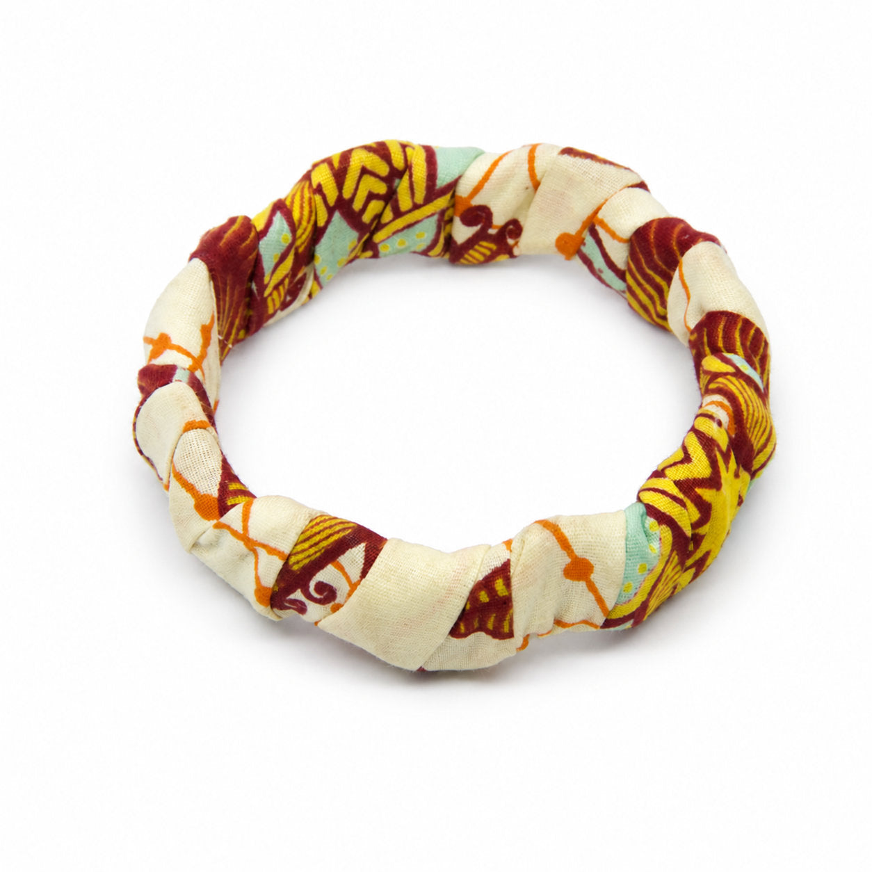 Bracelet jonc ondulé en bois recouvert de tissu wax beige ,bleu, détails jaunes et rouges, isolé sur fond blanc.