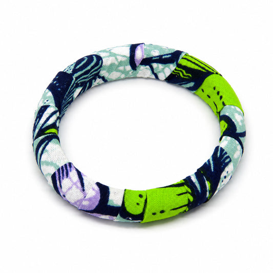 Bracelet jonc rond en bois recouvert de tissu wax vert, bleu marine et touche de violet, isolé sur fond blanc.