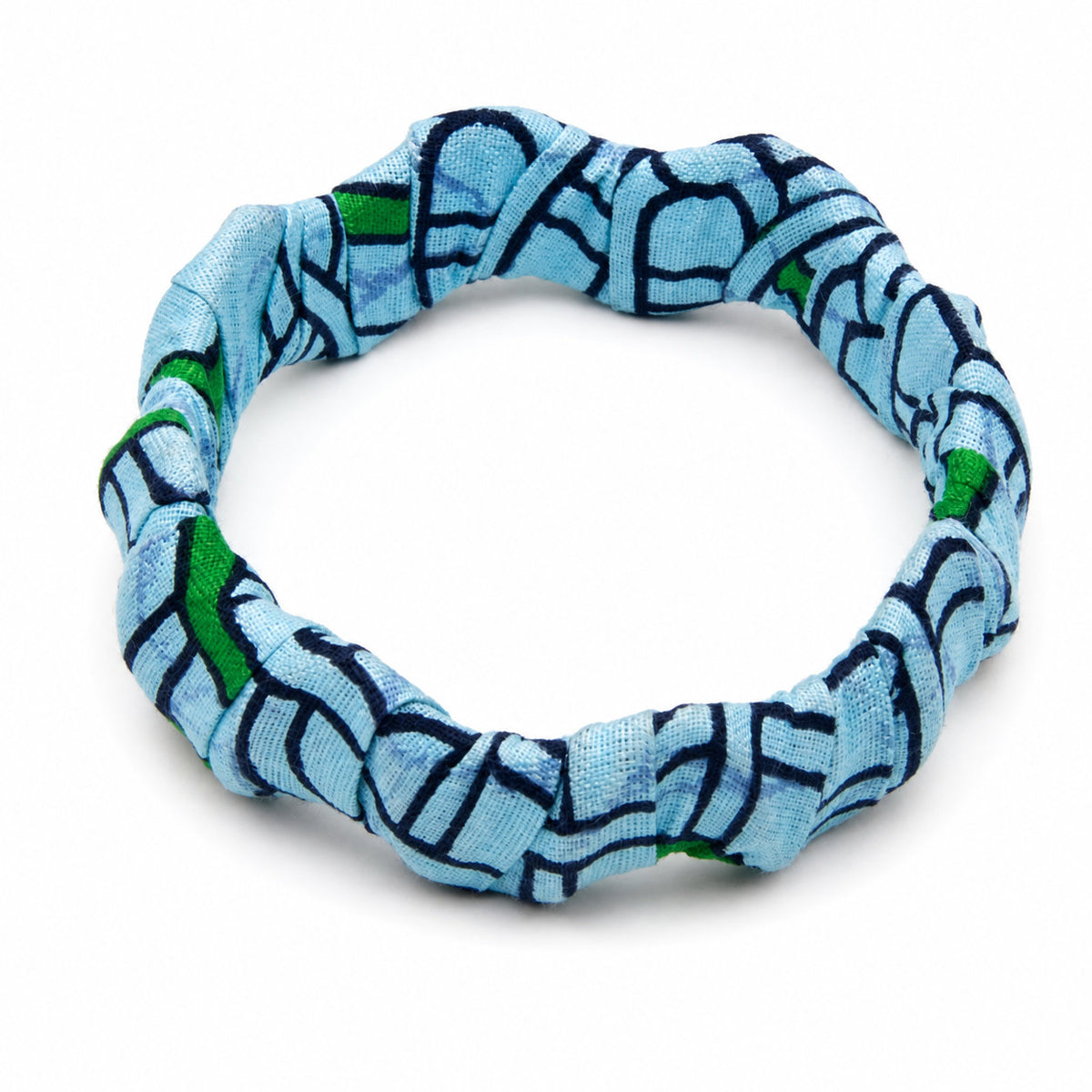 Bracelet jonc ondulé en bois recouvert de tissu wax bleu ciel aux motifs géométriques bleu marine et touches de vert, isolé sur fond blanc.