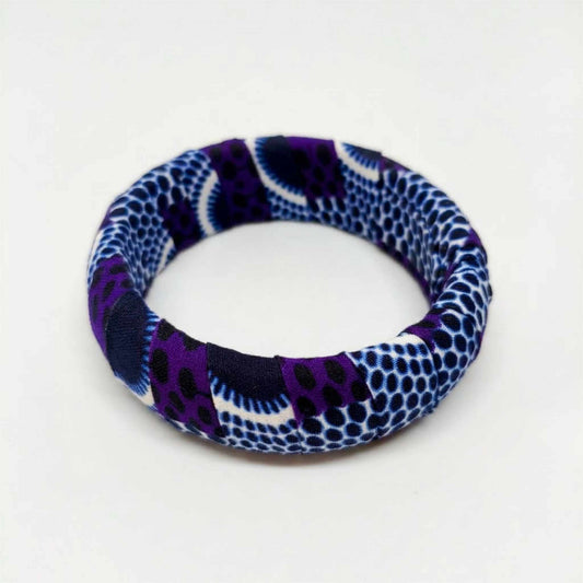 Bracelet jonc rigide artisanal recouvert de tissu wax aux motifs alvéolés violet, indigo et blanc, confectionné en France.