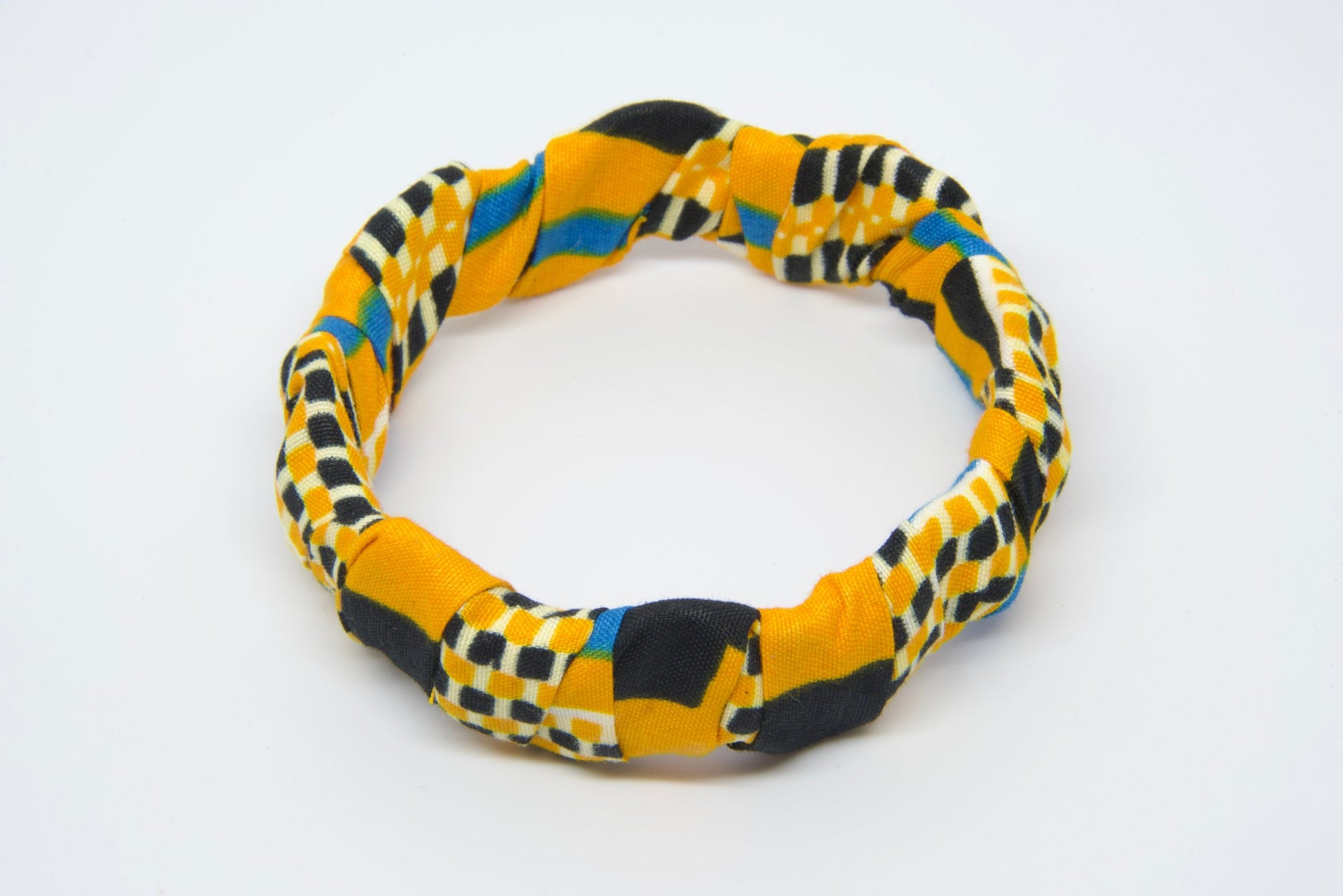 Vue produit bracelet torsadé artisanal recouvert de tissu wax jaune or à motifs géométriques damier noir et blanc avec touches de bleu turquoise - Bijou africain fait main Djêkoo Wax

