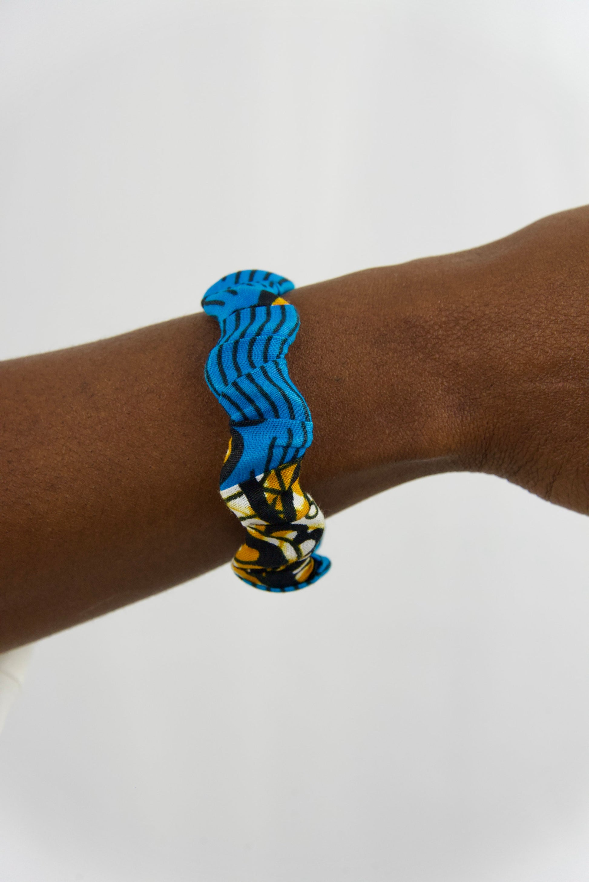 bracelet artisanal pour femme fait main en bois et tissu wax de couleurs bleu, noir, orange et blanc