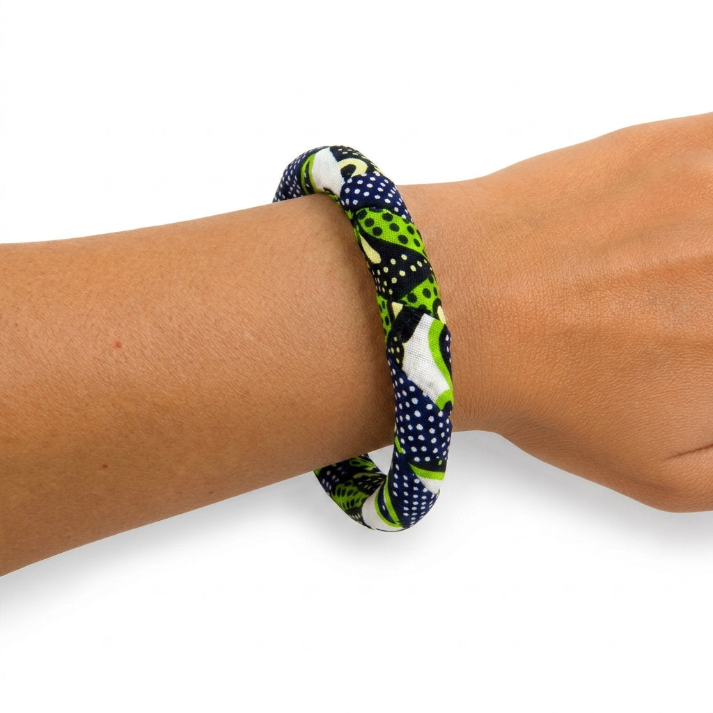 Bracelet en tissu wax vert, bleu marine et blanc porté au poignet.