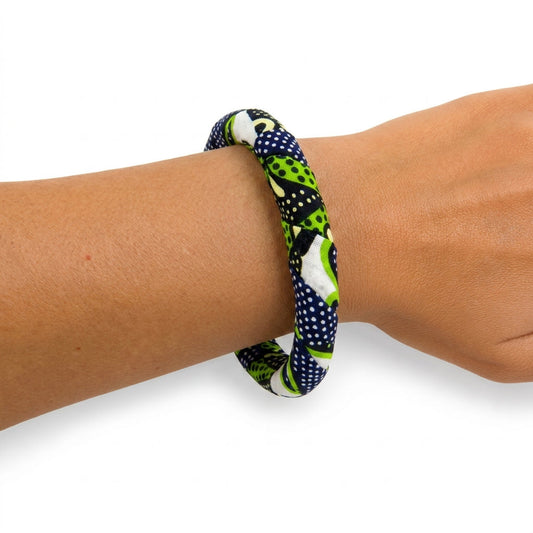 Bracelet en tissu wax vert, bleu marine et blanc porté au poignet.