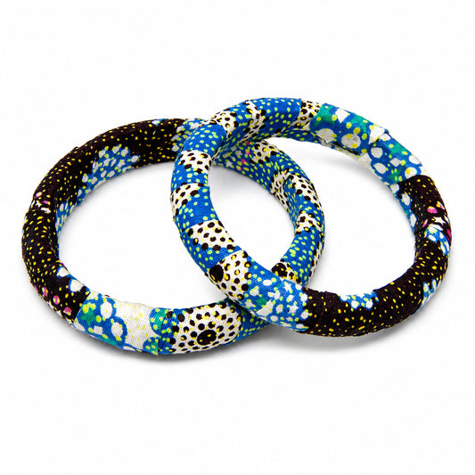 Duo de bracelets joncs ronds en bois recouverts de tissu wax bleu et noir à motifs pointillistes jaunes, isolés sur fond blanc.