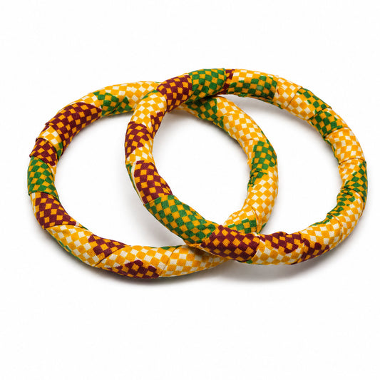 Duo de bracelets joncs ronds en bois recouverts de tissu wax à motifs damier jaune, vert et rouge bordeaux, isolés sur fond blanc.