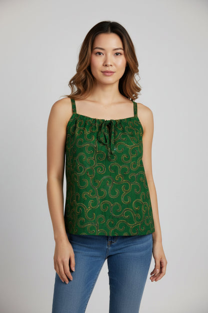 Femme portant un caraco bretelles en tissu wax vert kaki foncé à motifs arabesques jaune doré pointillés avec col carré froncé lien noué central et bretelles larges en tissu wax assorti - Mode africaine femme Djêkoo Wax