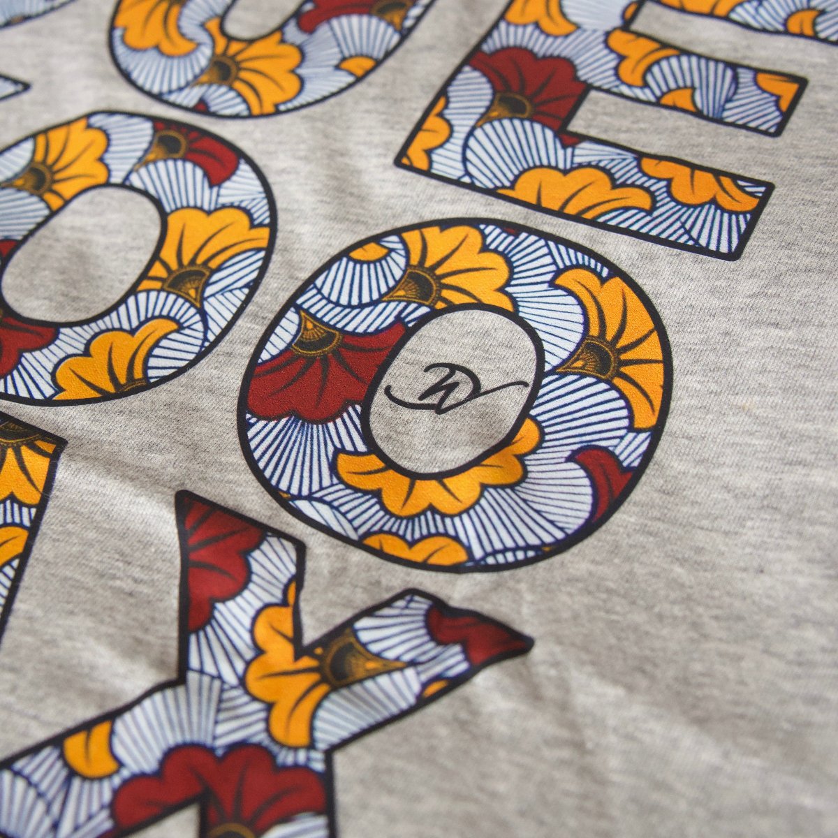 Gros plan du motif graphique wax Djêkoo Wax sur débardeur gris