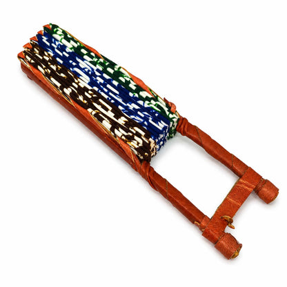 Éventail africain pliable présenté fermé, en tissu wax bleu, vert, marron et blanc, avec manche artisanal en bois.