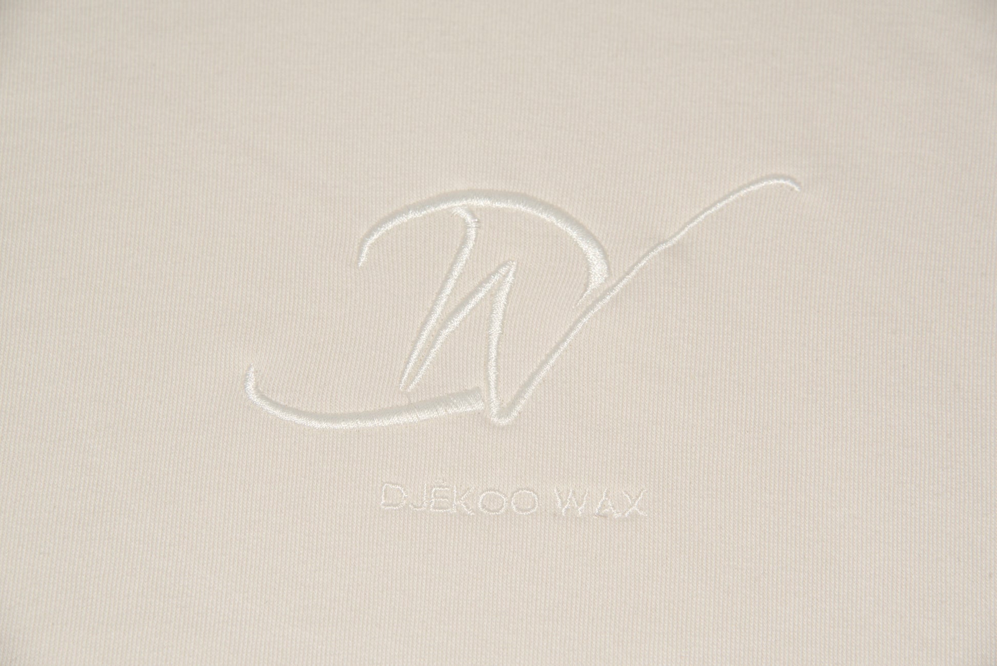 Broderie 10cm x 10cm beige du Logo Djêkoo Wax sur le devant du sweat à capuche