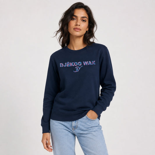 Femme portant un sweat bio unisexe marine avec motif wax Fleurs de Mariage Djêkoo Wax
