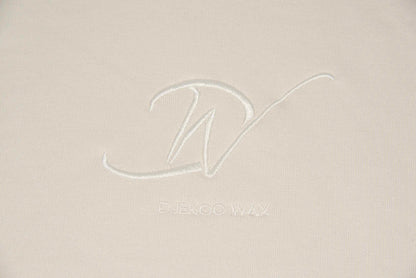 Détail du logo brodé sur sweat à capuche bio femme blanc cassé - Djêkoo Wax
