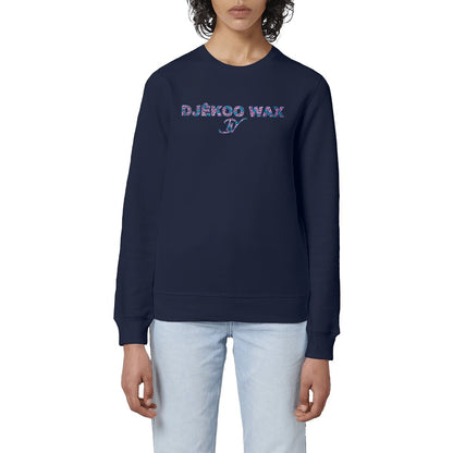 Femme portant un sweat-shirt col rond unisexe bio bleu marine à plat avec lettrage DJÊKOO WAX rempli de motifs wax fleurs de mariage rose fuchsia, bleu turquoise et violet et monogramme DW cursif - Vêtement éco-responsable