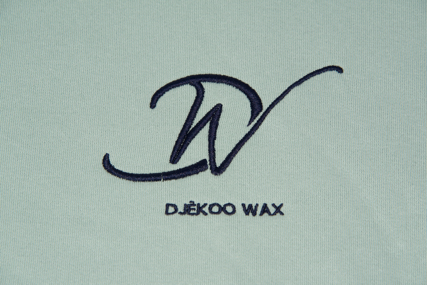 Broderie 10cm x 10cm bleu foncé du Logo Djêkoo Wax  sur le devant du sweat à capuche 