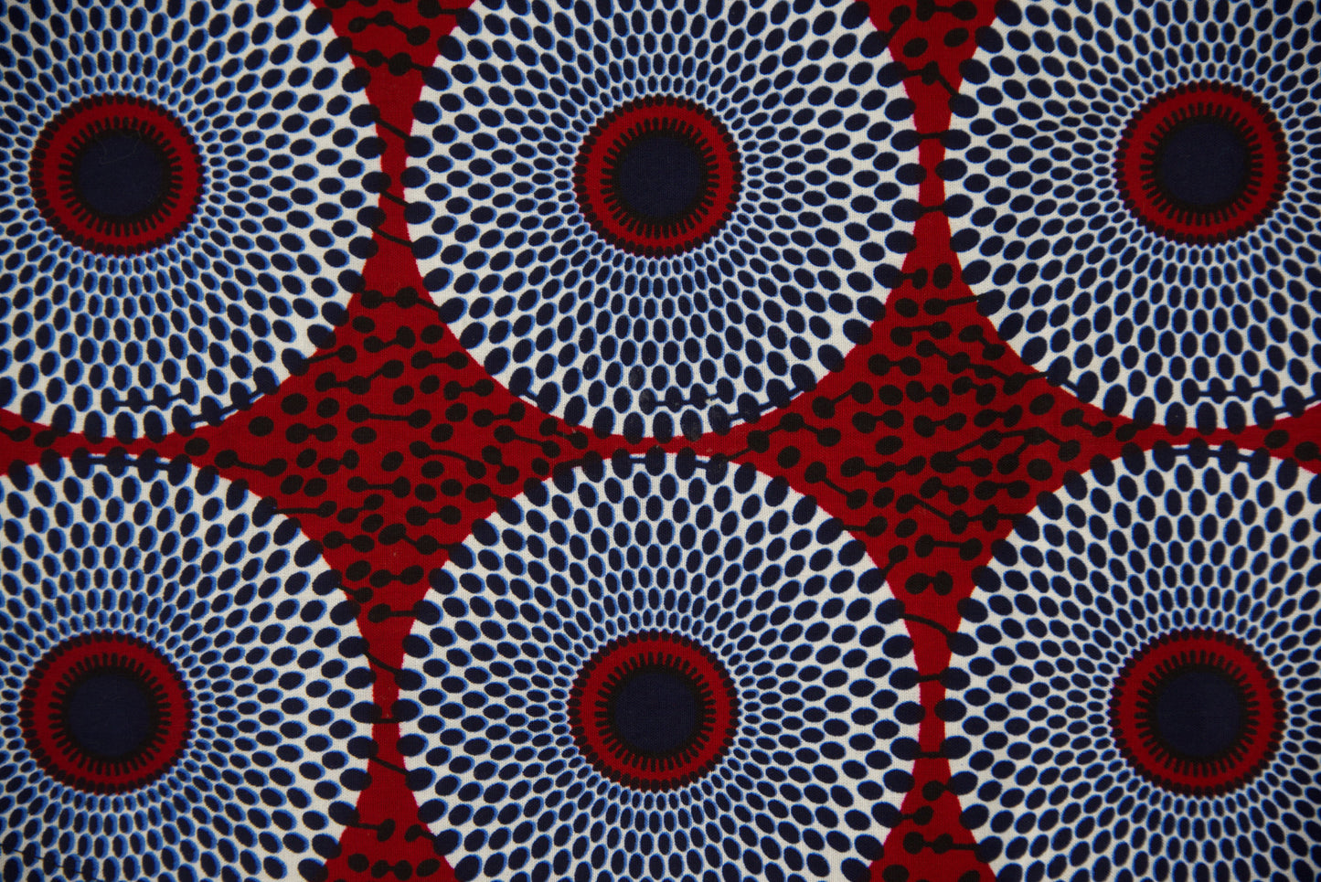 Gros plan tissu wax blanc cassé à grands motifs cercles concentriques bleu marine et rouge bordeaux pointillés avec étoiles géométriques rouges - Tissu africain premium Djêkoo Wax

