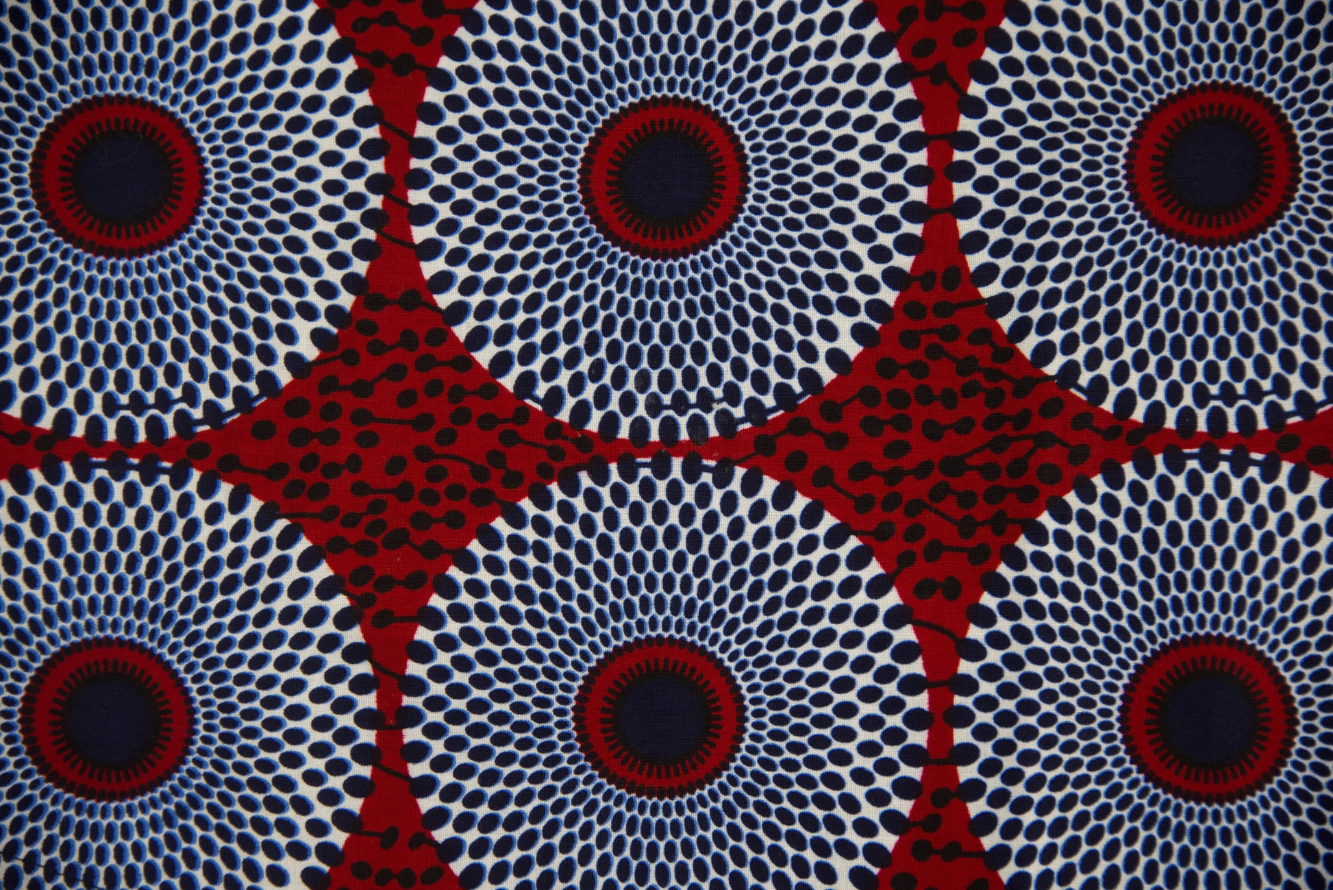 Gros plan tissu wax blanc cassé à grands motifs cercles concentriques bleu marine et rouge bordeaux pointillés avec étoiles géométriques rouges - Tissu africain premium Djêkoo Wax

