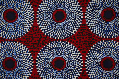 Gros plan tissu wax blanc cassé à grands motifs cercles concentriques bleu marine et rouge bordeaux pointillés avec étoiles géométriques rouges - Tissu africain premium Djêkoo Wax

