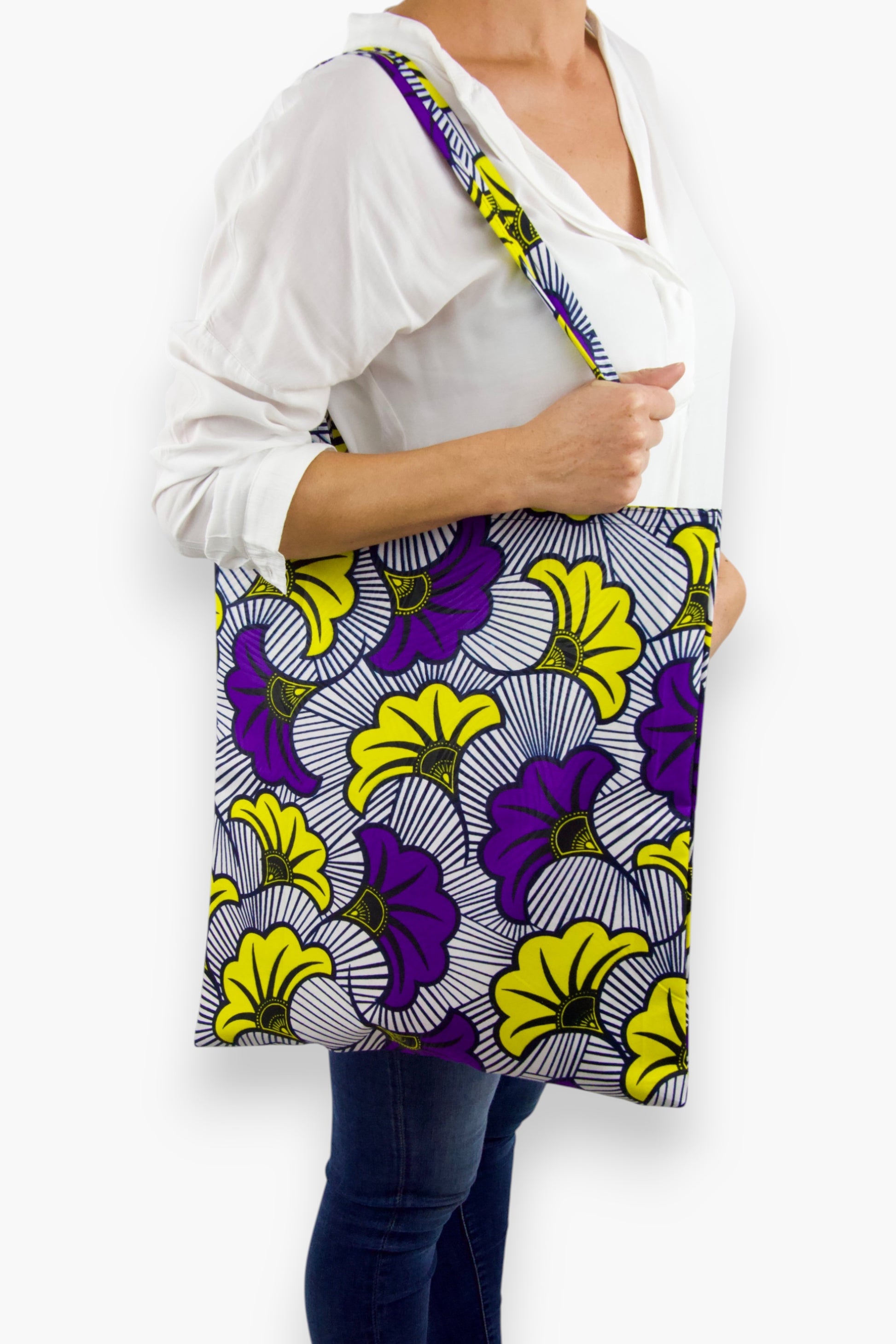 Tote bag artisanal porté à l’épaule, en tissu wax blanc, violet et jaune au motif Fleurs de mariage, avec longues anses assorties